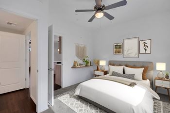 A bedroom with a large bed and a ceiling fan.
